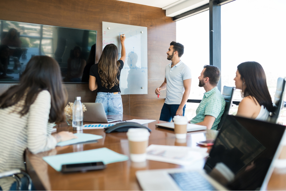 colleagues looking businesswoman writing whiteboard office during presentation